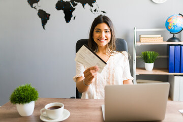 Portrait of a sales agent showing flight tickets