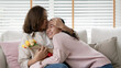 © ChayTee - Attractive beautiful asian middle age mum sit with grown up daughter give gift box and flower in family moment celebrate mother day. Overjoy bonding cheerful kid embrace relationship with retired mom.
