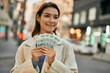 © Krakenimages.com - Young hispanic woman smiling happy holding polish zloty banknotes at the city