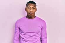 Young Black Man Wearing Casual Pink Sweater Making Fish Face With Lips, Crazy And Comical Gesture. Funny Expression.