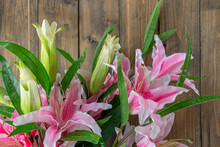 Bouquet Of Pink Lilies On A Wooden Background. Artificial Pink Lilies.