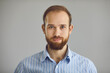 © Studio Romantic - Studio portrait of happy young man in office shirt with ginger beard and mustache looking at camera. Head shot of friendly salesman, consultant, or manager. Human face, people's appearance concept