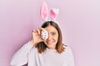 © Krakenimages.com - Young beautiful woman wearing cute easter bunny ears holding egg looking positive and happy standing and smiling with a confident smile showing teeth