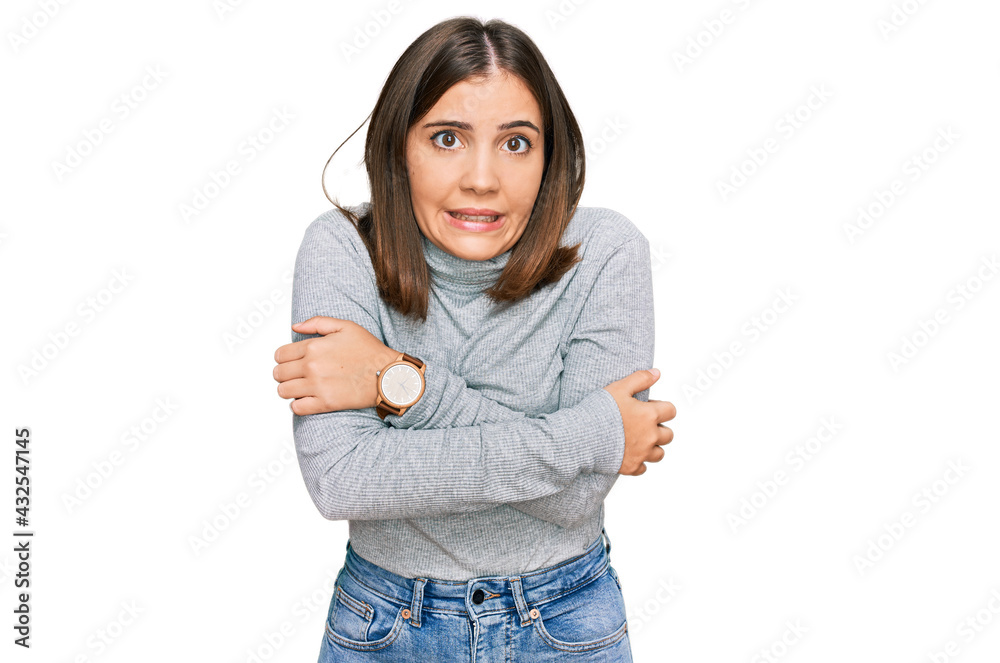 Young beautiful woman wearing casual turtleneck sweater shaking and freezing for winter cold with sad and shock expression on face