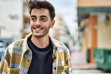 Handsome hispanic man smiling happy and confident at the city