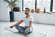 © gstockstudio - Totally relaxed young man doing yoga while sitting