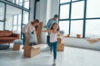 © gstockstudio - Happy young family smiling and unboxing their stuff