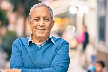 Wall Mural - senior grey-haired man with arms crossed smiling happy standing at the city.