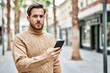 © Krakenimages.com - Young caucasian man with serious expression using smartphone at the city.