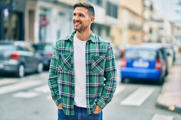 Wall Mural - Young caucasian man smiling happy standing at the city.