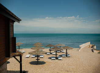 Wall Mural - Wooden beach umbrellas by the sea in clear weather