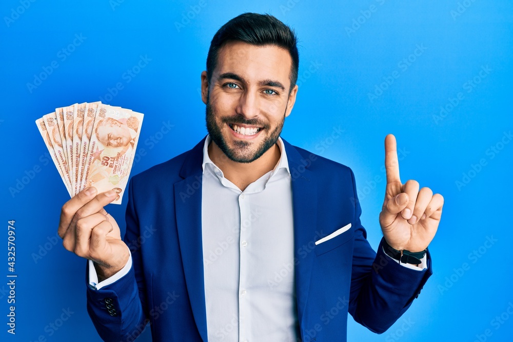 Turkish Rude Finger Young hispanic businessman wearing business suit holding turkish lira ...