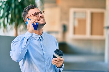 Poster - Young hispanic businessman talking on the smartphone and drinking coffee at the city.