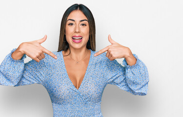 Young hispanic woman wearing casual clothes looking confident with smile on face, pointing oneself with fingers proud and happy.