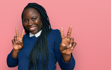 Sticker - Young black woman with braids wearing casual clothes smiling looking to the camera showing fingers doing victory sign. number two.