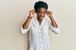 © Krakenimages.com - Young african american girl wearing casual clothes smiling pulling ears with fingers, funny gesture. audition problem