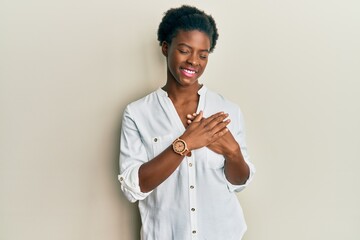 Poster - Young african american girl wearing casual clothes smiling with hands on chest with closed eyes and grateful gesture on face. health concept.