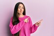 © Krakenimages.com - Young hispanic girl pointing with fingers to the side skeptic and nervous, frowning upset because of problem. negative person.