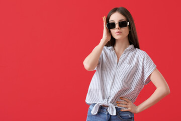 Poster - Beautiful young woman with stylish sunglasses on color background