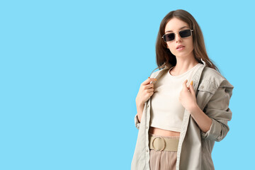 Poster - Beautiful young woman with stylish sunglasses on color background