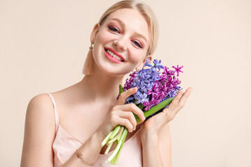 Wall Mural - Beautiful young woman with hyacinth flowers on light background