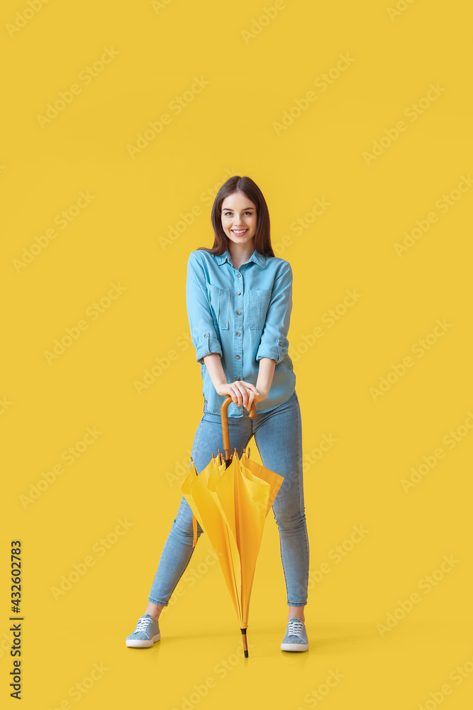 Stylish young woman with umbrella on color background