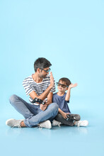 Father And Little Son Playing Video Games On Color Background