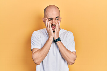 Sticker - Young bald man wearing casual white t shirt tired hands covering face, depression and sadness, upset and irritated for problem