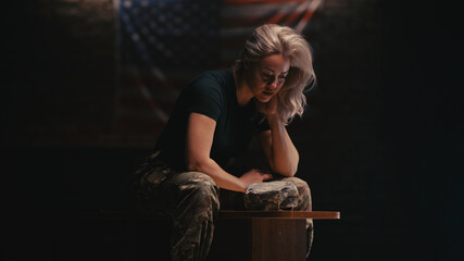 Exhausted female soldier resting on bench
