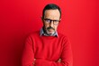 © Krakenimages.com - Middle age hispanic man wearing casual clothes and glasses skeptic and nervous, disapproving expression on face with crossed arms. negative person.