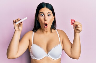 Poster - Beautiful brunette woman holding menstrual cup wearing underwear annoyed and frustrated shouting with anger, yelling crazy with anger and hand raised