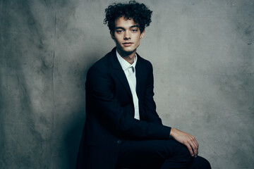 man in a suit sitting on a chair fashion modern style