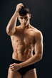 © SHOTPRIME STUDIO - handsome athletic man in dark shorts posing dark background