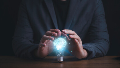 Poster - businessman hand protecting with lightbulb with virtual brain glowing , patent and creative idea inn
