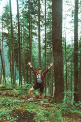 Wall Mural - woman backpacker enjoying view of forest in mountains