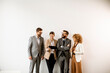 © BGStock72 - Multiethnic business people using digital tablet while standing by the wall in the office