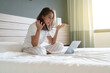 © T-REX - women on the bed with laptop video conference meeting