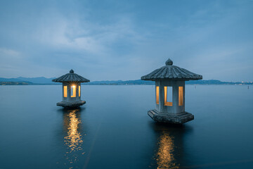 Night view of the beautiful landscape in West Lake in Hangzhou, with two stone lanterns in the lake