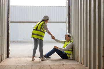 Young adult men and women industrial worker holding hand, encourage and cheer up after hard working day at container transportation import or export site. Teamwork and friendship workplace concept.