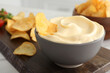 Potato chips and mayonnaise on wooden board, closeup