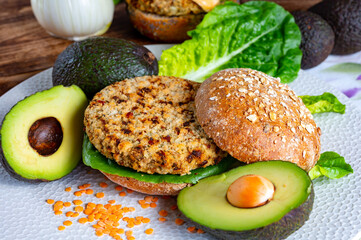 Wall Mural - Tasty vegetarian healthy food, homemade burgers made from orange lentils legumes with green lettuce and fresh ripe avocado