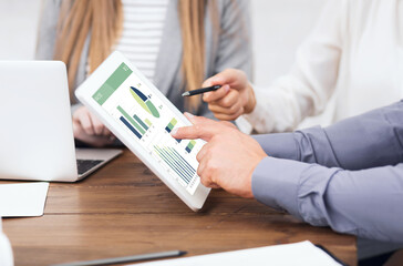 Cropped of business team analysing market, using digital tablet