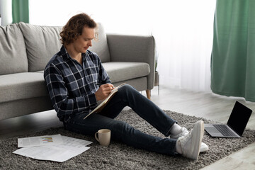 Poster - Millennial Guy Learning Taking Notes Sitting On Floor At Home