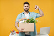 Young sad disappointed employee business man 20s wearing shirt stand work white office desk pc laptop hold cardboard box with stuff show thumb up gesture isolated on yellow background studio portrait