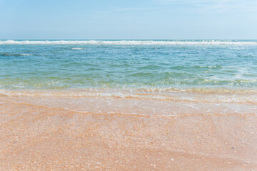 River to Sea Preserve in Marineland, Florida with beach nobody on sunny day and above view of orange sand waves on shore turquoise water