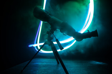Wall Mural - silhouette of a astronomy telescope on dark foggy backlight.