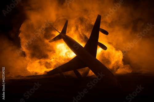 Air Crash. Burning falling plane. The plane crashed to the ground. Decorated with toy at dark fire background. Air accident concept.