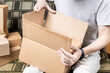 © Andrii - male person indoors unpack cardboard parcel package. men opening box. delivery service concept. online shopping conceptual