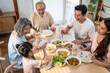 © Kawee - Top view shot of Asian big family enjoy eating food in the kitchen.