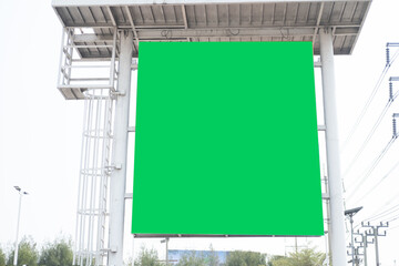 Empty billboard with chroma key green screen, on sky.